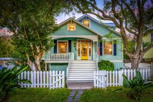 een groen huis met een wit hek ervoor bij Historic 1926 Summerwind with Heated Pool - 3 Blocks to Beach in Galveston