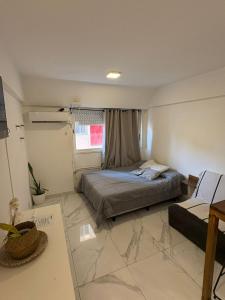 une petite chambre avec un lit et une fenêtre dans l'établissement Monoambiente en el corazón de barrio sur, à San Miguel de Tucumán