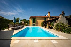a swimming pool in front of a house at Villa Nika - Rustic Stone House with Heated Pool in Rasopasno