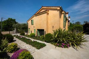 a building with a garden with flowers and plants at Villa Nika - Rustic Stone House with Heated Pool in Rasopasno