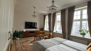 Olives Marina Apartment Old Town Gdańsk في غدانسك: غرفة نوم بسرير وتلفزيون ونوافذ