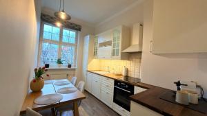 Olives Marina Apartment Old Town Gdańsk في غدانسك: مطبخ مع طاولة وغرفة طعام