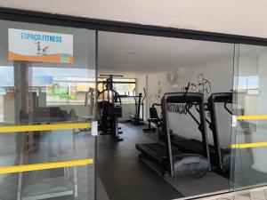 a gym with treadmills and ellipticals in a building at Porto Marina in Salvador