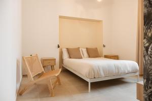 a bedroom with a bed and a wooden chair at Casa Dante in Putignano