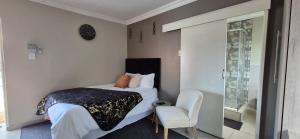 a small bedroom with a bed and a chair at Ekuhlaleni Room 6 in Pretoria