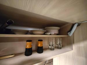 Drie flessen en glazen staan op een plank in een keuken. bij The Little Owls Nest in Rovaniemi