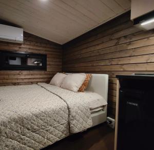 a bedroom with a bed in a wooden wall at The Little Owls Nest in Rovaniemi