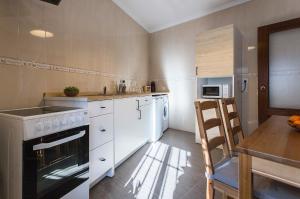 eine Küche mit weißen Geräten und einem Holztisch in der Unterkunft Paco del Molino in Grazalema + 11 Fotos