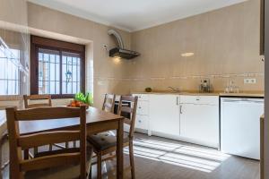 eine Küche mit weißen Schränken und einem Holztisch in der Unterkunft Paco del Molino in Grazalema