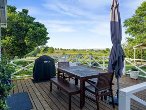 een tafel en stoelen en een parasol op een terras bij Cosy Guesthouse in Tranquil Puriri, Thames in Thames