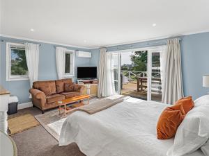 een slaapkamer met een bed en een woonkamer bij Cosy Guesthouse in Tranquil Puriri, Thames in Thames