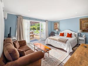 een woonkamer met een bed en een bank bij Cosy Guesthouse in Tranquil Puriri, Thames in Thames +14 foto's