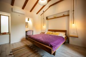 a bedroom with a large bed with a purple blanket at Villa Nika - Rustic Stone House with Heated Pool in Rasopasno +66 photos
