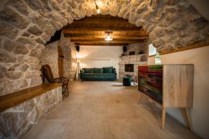 a living room with a stone wall and a couch at Villa Nika - Rustic Stone House with Heated Pool in Rasopasno