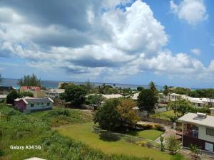 a view of a small town with houses and the ocean at Modern studio apartment near beach in Saint James +3 photos