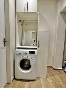 une machine à laver dans une pièce avec un miroir dans l'établissement Modern studio apartment in Asunción, à Asuncion 4 autres photos