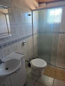 een badkamer met een douche, een toilet en een wastafel bij Férias em Itapema 04 in Itapema