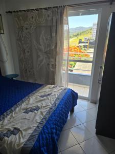 een slaapkamer met een bed en een raam met uitzicht bij Férias em Itapema 04 in Itapema