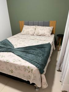 un letto con una coperta verde e bianca sopra di Sossego Potiguar a Parnamirim Altre 9 foto