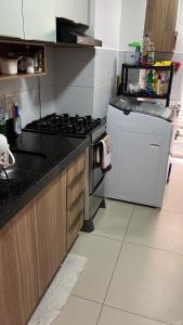 a kitchen with a stove and a sink and a refrigerator at Sossego Potiguar in Parnamirim
