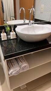 a bathroom counter with a sink and towels on it at Sossego Potiguar in Parnamirim