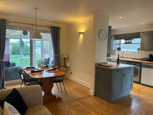 a kitchen and living room with a table and a dining room at 5 Edgebury in Puriton