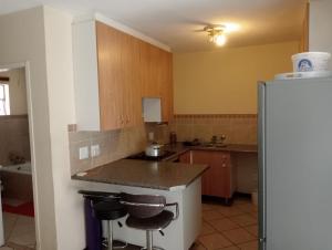een keuken met een aanrecht en een koelkast bij Fairway Gardens in Pretoria +2 foto's