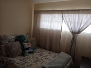 een teddybeer op een bed in een slaapkamer bij Fairway Gardens in Pretoria