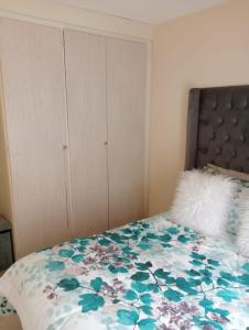 een slaapkamer met een bed met een bloemenbed bij Fairway Gardens in Pretoria