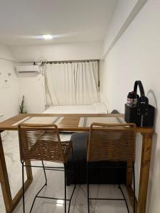 une pièce avec une table et deux chaises et un lit dans l'établissement Monoambiente en el corazón de barrio sur, à San Miguel de Tucumán