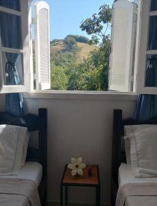 een venster met een bloem op een tafel in een kamer bij pousada talho da serra tempera in Valença