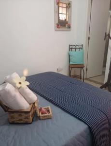 een slaapkamer met een bed en een mand met handdoeken bij pousada talho da serra tempera in Valença +2 foto's