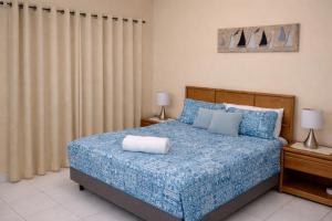 西湾SUITE 4, BLUE PAVILION - Steps to BEACH的一间卧室，里面有一张床，铺着蓝色被子。