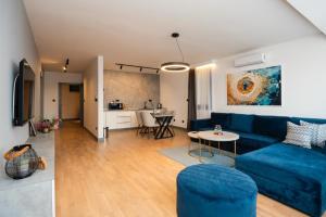 a living room with a blue couch and a table at Crystal Apartments Old Town Sarajevo in Sarajevo
