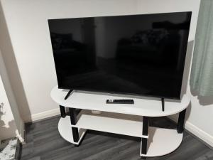 Elle comprend une télévision à écran plat sur une table blanche. dans l'établissement Rowe Terrace Workington, à Workington