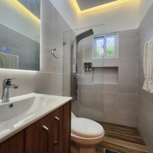 een witte badkamer met een wastafel en een toilet bij Villa Koi Oasis Punta Cana in Punta Cana