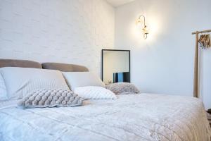 Un dormitorio con una cama con almohadas y un espejo. en Belloro, en Zanica