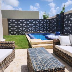 een terras met een zwembad en een tafel en stoelen bij Villa Koi Oasis Punta Cana in Punta Cana