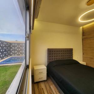 een slaapkamer met een bed en uitzicht op een zwembad bij Villa Koi Oasis Punta Cana in Punta Cana