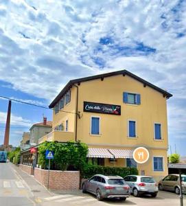 ein großes gelbes Gebäude mit davor geparkt in der Unterkunft Apartma Casa della Pizza - Parking included in Izola