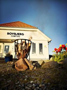 una señal frente a un edificio con una casa en Bovbjerg Camping, en Lemvig