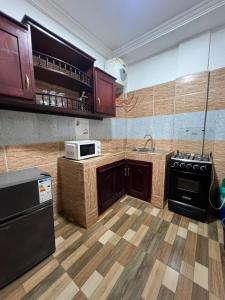a kitchen with wooden cabinets and a stove top oven at Fadilimmo Bsa app 201 in Yaoundé