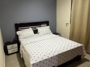 a bedroom with a bed with a polka dot bedspread at Fadilimmo Bsa app 201 in Yaoundé