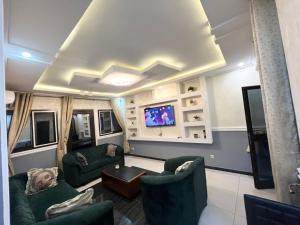 a living room with two green couches and a tv at Fadilimmo Bsa app 201 in Yaoundé