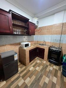 a kitchen with a sink and a stove top oven at Fadilimmo Bsa app 201 in Yaoundé +2 photos
