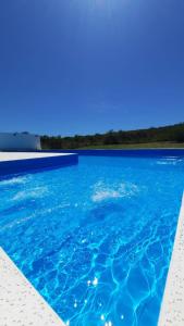 een zwembad met blauw water en een blauwe lucht bij Lucero de Brochero in Villa Cura Brochero