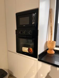 een magnetron op een fornuis bij DjossayaHomes in North Legon