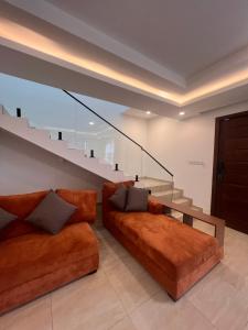 a living room with a couch and a staircase at DjossayaHomes in North Legon