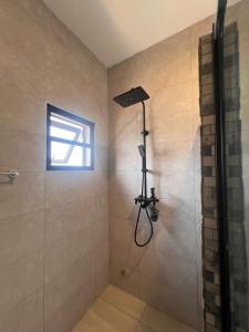 een badkamer met een douche met een douchekop bij DjossayaHomes in North Legon +116 foto's