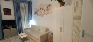 a living room with a white couch and a tv at Privat Appartment Room Martz Dorf in Vienna